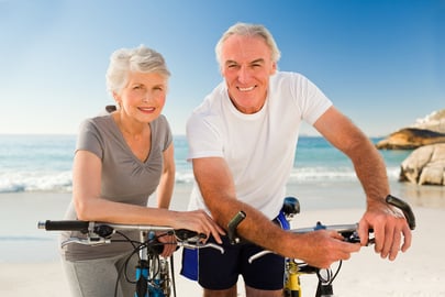 Retired couple with their bikes on the beach